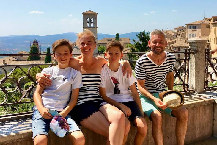 Een foto van mijn gezin op een muurtje in Assisi Umbrië Italië. Op de achtergrond het Arno dal.